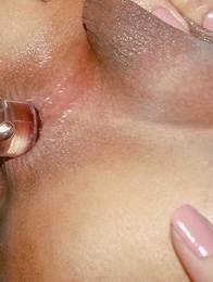 Tall and sexy Ladyboy Swan is sitting on the bed wearing a pink multi-colored blouse, red panties, and flat white sneakers.